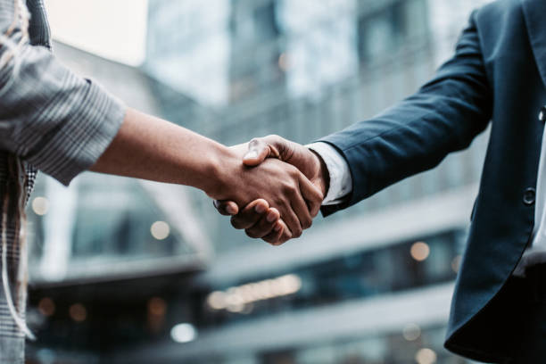 meeting success. two business persons shaking hands standing outside - 企业 個照片及圖片檔