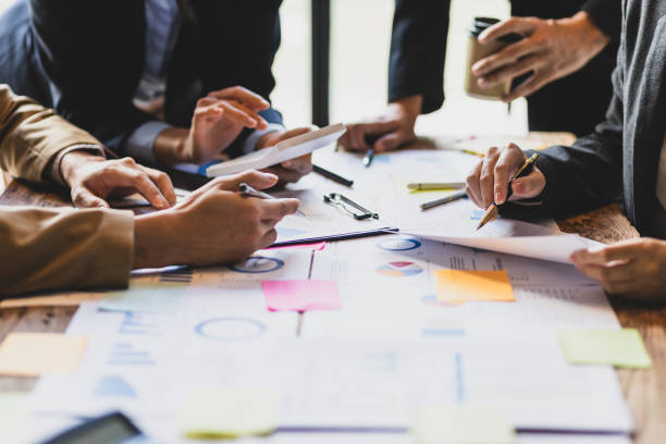 brainstorm business meeting to discuss analysis of financial figures, graphs and growth charts of business investments to plan new business projects. - 企业 個照片及圖片檔